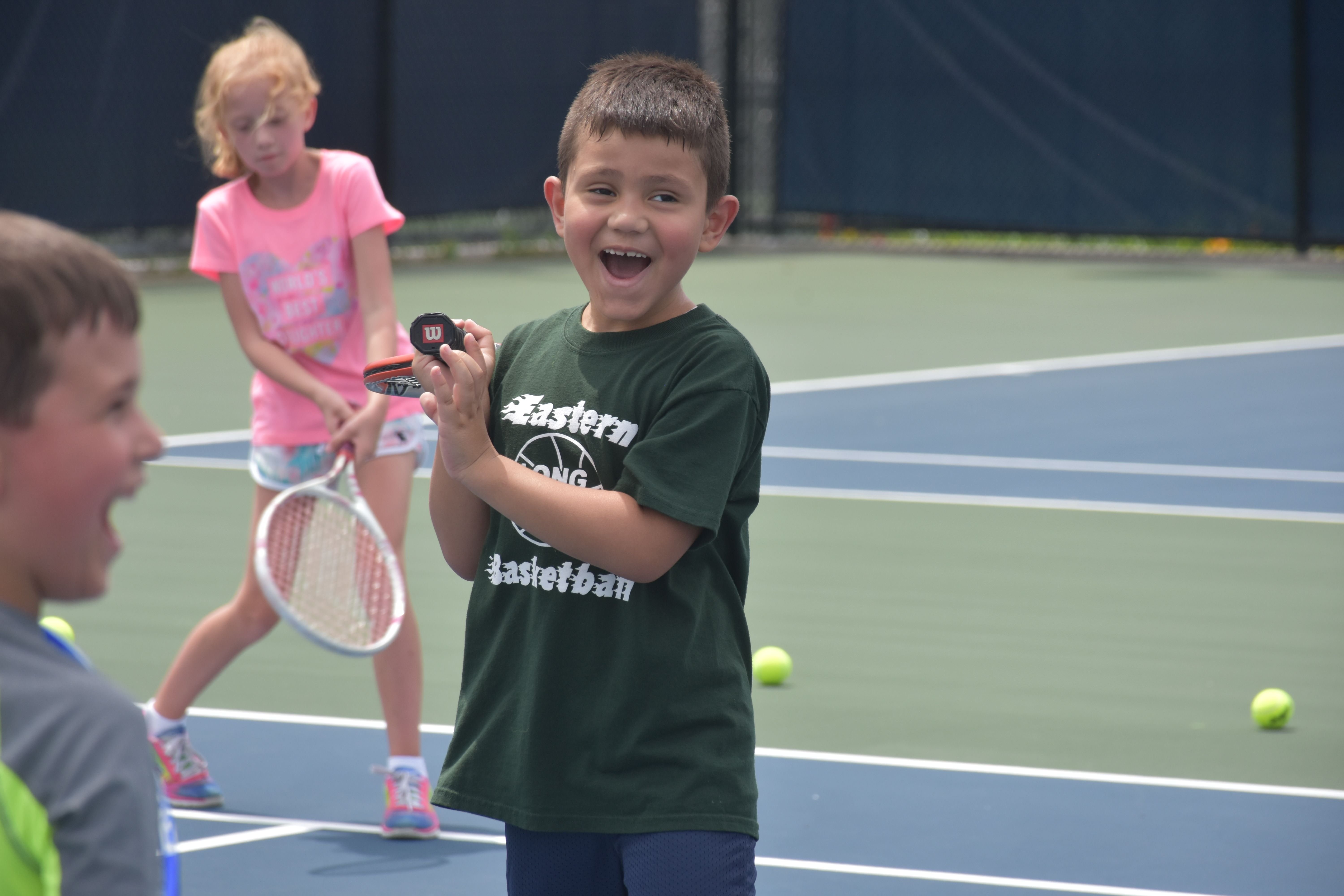 boy holding racquet smiling